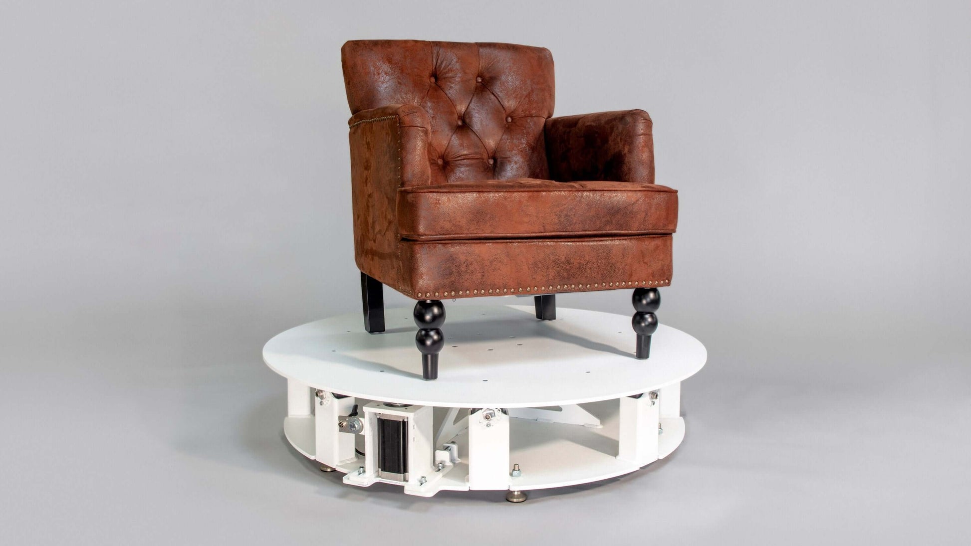 Platinum XXL turntable showcasing a vintage brown tufted chair for 360 product photography.